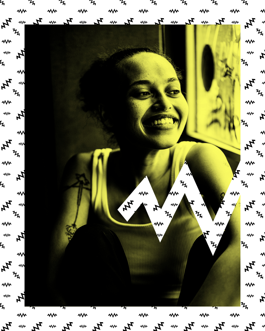 Die Künstlerin Gündalein sitzt lächelnd vor einem neutralen Hintergrund und blickt dabei in die Kamera.